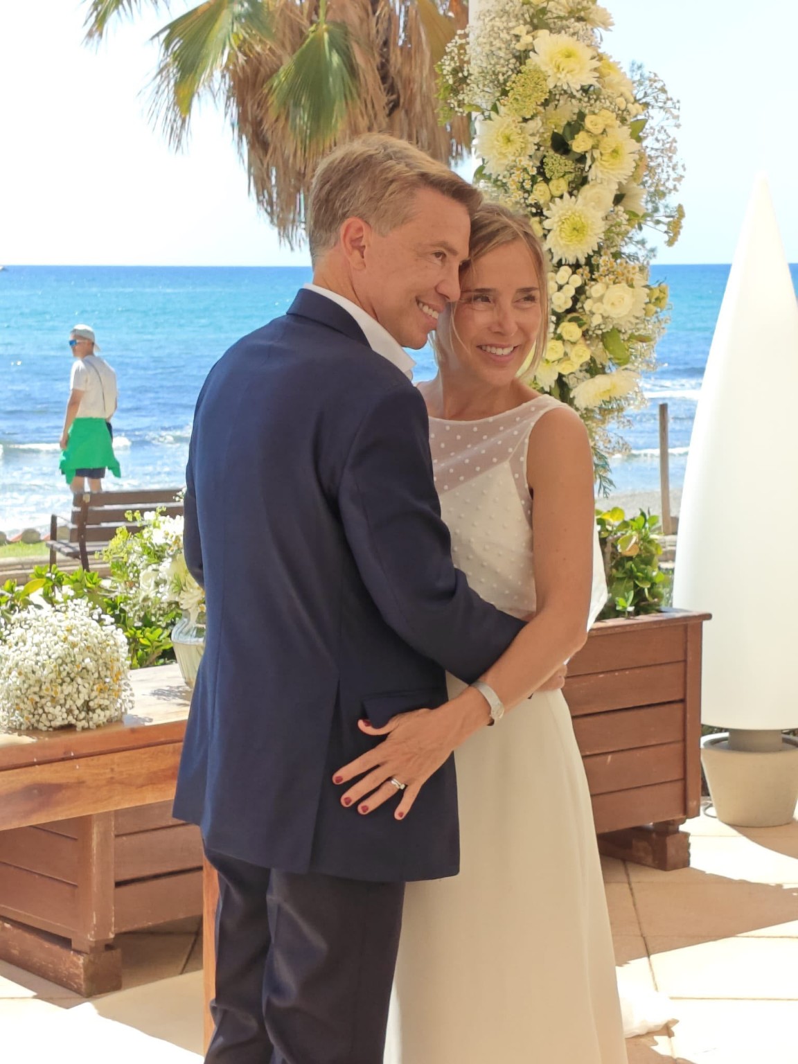 Pareja recién casada abrazándose junto al mar